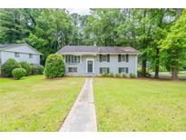Charming two-story home with a well-manicured lawn and a classic brick facade with black shutters at 4669 Birch Ridge Trl, Stone Mountain, GA 30083