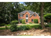 Charming two-story brick home with lush landscaping and mature trees at 6435 Ivey Creek Cir, Cumming, GA 30040