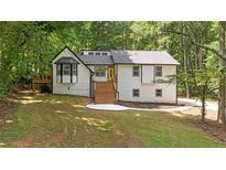 Charming two-story home with a white exterior, black trim, and a bright yellow front door at 3713 Brigantine Ct, Acworth, GA 30102