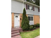 Charming townhome featuring a tidy front lawn and well-maintained exterior with neutral siding and maroon shutters at 405 Fairburn Sw Rd # 64, Atlanta, GA 30331
