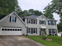 Charming two-story home with gray painted brick, black shutters, and a well-manicured lawn at 4635 Tims Pl, Snellville, GA 30039