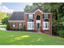 Charming two-story brick home with manicured lawn and dark shutters at 1001 Braelin Ct, Woodstock, GA 30189