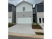 Charming townhome featuring a two-car garage and neutral-toned exterior at 5522 Cosimo Rd, Fairburn, GA 30213