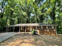 Charming brick home with a covered carport and lush green surroundings at 6106 Oak Hill Sw Dr, Austell, GA 30168