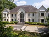 Elegant two-story home with a grand entrance, manicured landscaping, and a circular driveway at 70 Finch Forest Trl, Atlanta, GA 30327