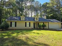 Charming single-story home with a well-maintained lawn and traditional design elements at 115 Bond Dr, Ellenwood, GA 30294
