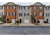 Charming townhome featuring a private garage, complemented by well-maintained landscaping and traditional architectural details at 5357 Beaver Br, Norcross, GA 30071