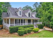 Charming two-story traditional home featuring a welcoming front porch and manicured landscaping at 212 Warrenton Dr, Douglasville, GA 30134