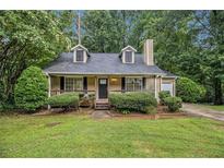 Charming single-Gathering home featuring a cozy front porch and well-maintained landscaping at 2120 Glenwood Downs Dr, Decatur, GA 30035