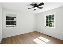 Bright bedroom with hardwood floors, modern ceiling fan, and white walls and trim at 1227 Kenilworth Dr, Atlanta, GA 30310