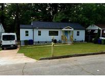 Charming home featuring a newly-mowed lawn, fresh paint, and a bright blue front door at 1227 Kenilworth Dr, Atlanta, GA 30310