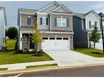 Charming two-story home with brick and gray siding, a two-car garage, and a well-manicured lawn at 2690 Ravencliff Dr, Austell, GA 30168