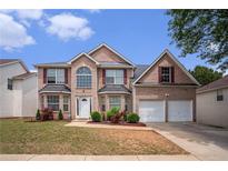 Traditional two-story brick home featuring a two-car garage and manicured front lawn at 3740 Arminto Dr, Ellenwood, GA 30294