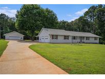 Charming ranch-style home with a well-maintained lawn, attached garage, and separate garage building at 95 Oak Grove Cir, Mcdonough, GA 30253