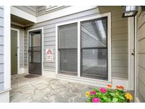 Cozy patio area featuring stone flooring, gray siding, flowers and a screened door at 4977 Meadow Ln, Marietta, GA 30068