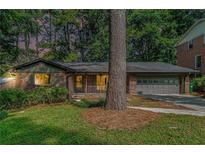 Charming brick home with a well-maintained lawn and an attached two-car garage at 1260 Fork Creek Trl, Decatur, GA 30033