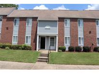 Exterior of brick and vinyl townhouse with well-maintained lawn and trimmed bushes at 636 North Ave # 11E, Jonesboro, GA 30236
