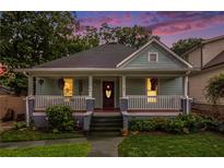 Charming bungalow-style home with a welcoming front porch, lush landscaping, and a well-manicured lawn at 1292 Eubanks Ave, East Point, GA 30344