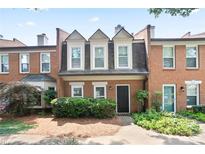 Charming brick townhome featuring a well-maintained front yard and classic architectural details at 4167 Oakwood Way, Duluth, GA 30096