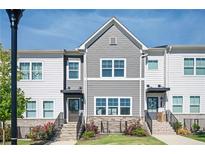 Charming townhome featuring stone accents, landscaped yard, and a welcoming entrance, perfect for modern living at 1947 Drew Nw Dr, Atlanta, GA 30318