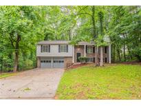 Charming split-level home featuring a two-car garage and lush green landscaping at 740 Stoneside Ct, Stone Mountain, GA 30083
