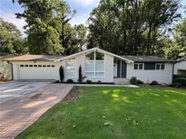 Charming one-story home with brick and siding accents, lush lawn, and an attached two-car garage at 453 James Street Sw, Lilburn, GA 30047