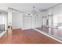 Spacious living room featuring wood floors, a mirrored wall, and an elegant chandelier at 1213 Camelot Dr, Atlanta, GA 30349