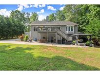 The backyard features a deck, hot tub, a gazebo and a spacious lawn surrounded by mature trees at 2730 Samples Rd, Cumming, GA 30041