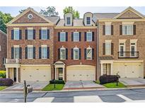 Charming brick townhomes featuring attached garages and manicured lawns offer inviting curb appeal at 4742 Legacy Cove Ln, Smyrna, GA 30126