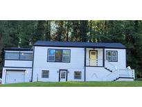 Charming two-story home with white siding, black trim, and a bright yellow front door at 2170 Beecher Sw Cir, Atlanta, GA 30311