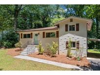 Charming home with brick exterior, shutters, manicured lawn, and inviting front entrance at 481 Meadowbrook Se Dr, Marietta, GA 30067