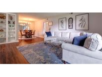 Bright living room featuring a comfortable sofa, blue accent pillows, and a dining area in the background at 6851 Roswell Rd # G3, Atlanta, GA 30328