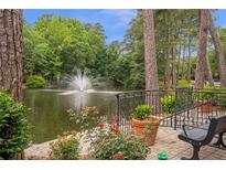 A serene pond view with a central fountain, lush trees, flowers and benches create a park-like atmosphere at 26303 Plantation Ne Dr # 303, Atlanta, GA 30324