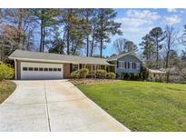 Charming single-story home with a well-manicured lawn and a two-car garage at 860 Valleymeade Se Dr, Marietta, GA 30067