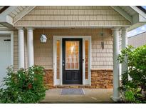 Inviting front entryway with decorative stone accents and a black door with sidelights at 2685 Gateview Ct, Cumming, GA 30040