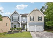 Charming two-story home with a two-car garage, well-maintained lawn, and inviting curb appeal at 7530 Springbox Dr, Fairburn, GA 30213