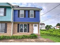 Charming townhome featuring a blue exterior, brick accents, manicured lawn, and a welcoming white front door at 128 Evergreen Trl # 4, Cartersville, GA 30121