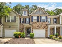 Two-story brick and vinyl townhome with a one-car garage, black shutters, and manicured landscaping at 3335 Thornbridge Dr, Powder Springs, GA 30127
