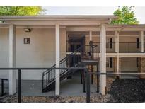 Apartment building exterior featuring stairway entrance and neutral-toned stucco finish at 1150 Collier Nw Rd # 10L, Atlanta, GA 30318
