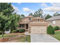 Charming two-story home featuring a covered porch and a two-car garage with a well-manicured front yard at 238 Balsam Dr, Canton, GA 30114