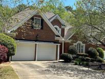 Charming two-story brick home with a well-manicured lawn, mature trees, and a two-car garage at 2612 Peterboro Row, Marietta, GA 30062