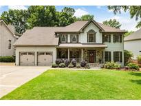 Charming two-story home features a well-manicured lawn, stone accents, and a welcoming front porch perfect for relaxing at 10530 Tuxford Dr, Alpharetta, GA 30022