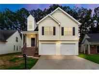 Charming two-story home boasts a two-car garage, inviting staircase, and neatly maintained front yard at 2169 Wingfoot Pl, Decatur, GA 30035