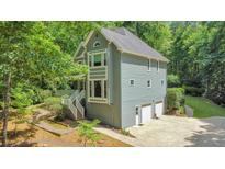 Charming two-story home features a two-car garage and beautiful landscaping at 405 W Leslie Ct, Woodstock, GA 30188