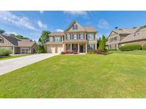Charming two-story home with lush green lawn, three-car garage and a basketball hoop on the driveway at 456 Rockford Sw Pass, Marietta, GA 30064