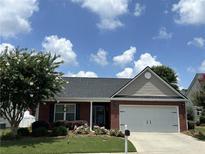 Charming single-story home with a brick facade, well-manicured lawn, and a two-car garage at 804 Village Pl, Loganville, GA 30052
