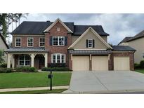 Beautiful two-story brick home with a well-manicured lawn, two-car garage, and stylish architectural details at 508 Highland Drive Dr, Woodstock, GA 30188