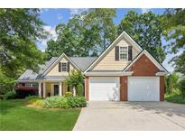 Charming home featuring a manicured lawn and a two-car garage, blending brick and siding for a classic look at 726 Sunset Ridge Ln, Lawrenceville, GA 30045