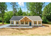 Charming home with a blue front door and wooden shuttered windows framed by lush greenery at 38 Creek Se Dr, Cartersville, GA 30121