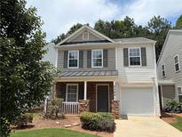 Charming two-story home featuring a cozy front porch, attached garage, and well-maintained landscaping at 5345 Mountain Top Pl, Cumming, GA 30041